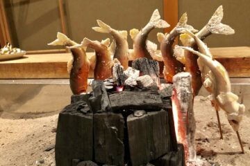 Skewered ayu sweetfish slow-grilled over charcoal on an irori hearth at Yanagiya in Gifu, Japan’s legendary wild meat and river fish cuisine restaurant known for seasonal game meat and river fish.