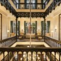 Historic French colonial courtyard at Sofitel Legend Metropole Hanoi featuring elegant balconies, warm lighting, and classic architecture