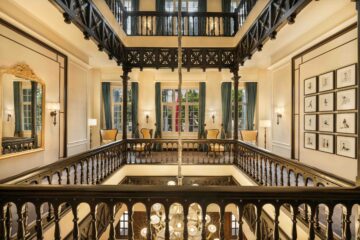 Historic French colonial courtyard at Sofitel Legend Metropole Hanoi featuring elegant balconies, warm lighting, and classic architecture